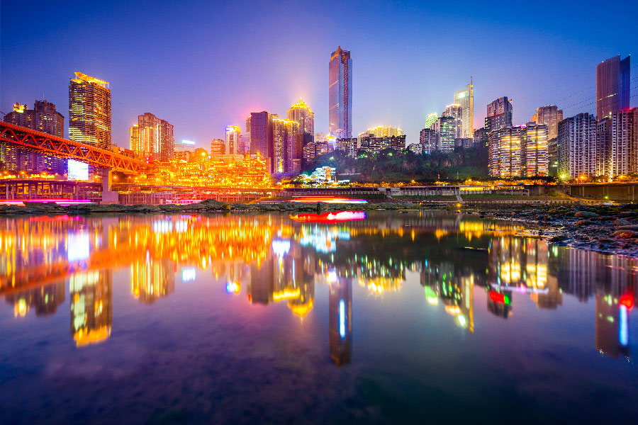 un rio que refleja las luces de una ciudad con rascacielos de ensueño.
