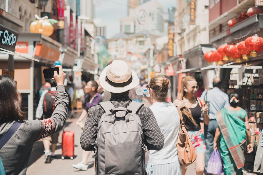 viajero dando la espalda, personas caminando en una calle de comercio Chino